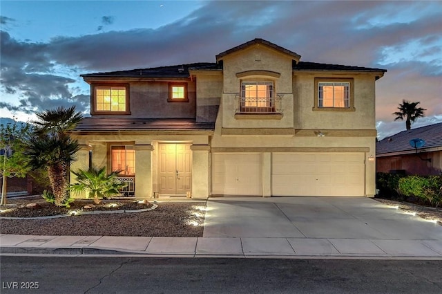 mediterranean / spanish house featuring stucco siding, roof mounted solar panels, a garage, and driveway