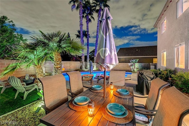 view of patio / terrace with outdoor dining area, a fenced in pool, and a fenced backyard