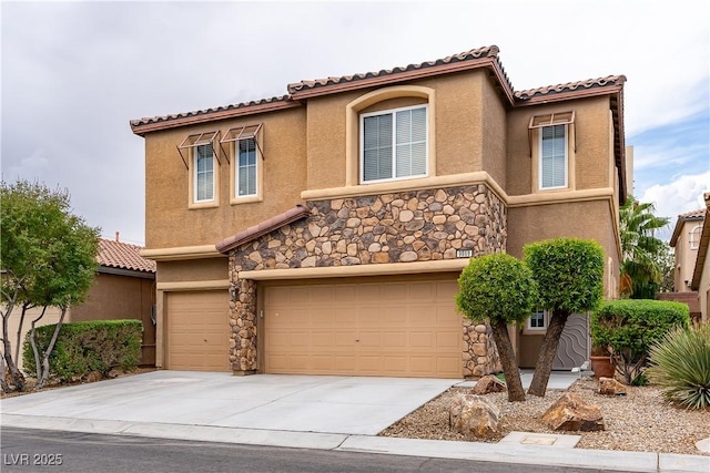 mediterranean / spanish house featuring stucco siding, concrete driveway, a garage, stone siding, and a tiled roof