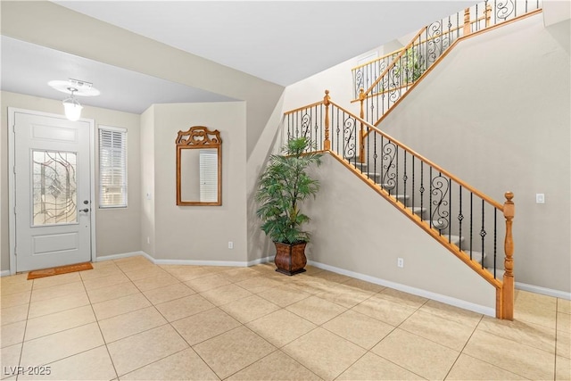 tiled entryway with stairway and baseboards