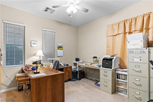 home office with light carpet, visible vents, and ceiling fan