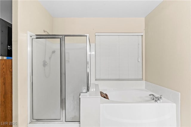 bathroom featuring a bath and a shower stall