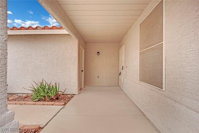 doorway to property with a tile roof and stucco siding