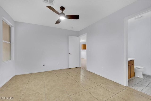 empty room with light tile patterned floors, visible vents, baseboards, and a ceiling fan