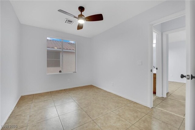 spare room with light tile patterned floors, visible vents, baseboards, and ceiling fan