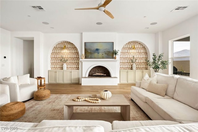 living area featuring wood finished floors, recessed lighting, a ceiling fan, and visible vents