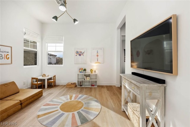 living area with light wood-style flooring and baseboards