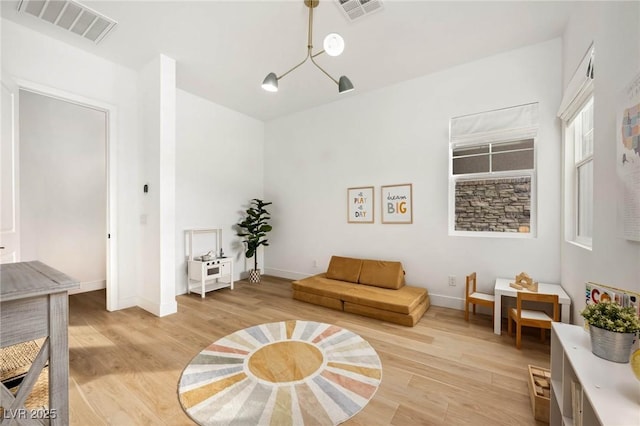 living area featuring visible vents, baseboards, and light wood-style flooring