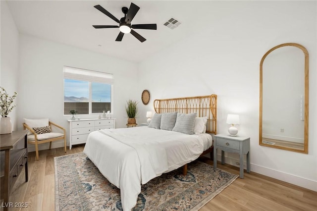 bedroom featuring visible vents, baseboards, ceiling fan, and light wood finished floors