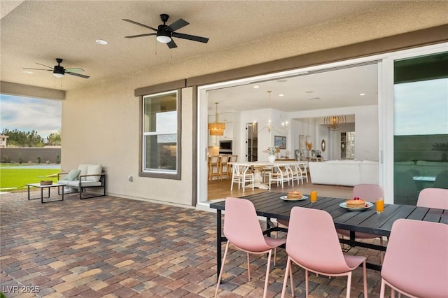 view of patio with outdoor dining area and ceiling fan