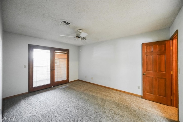 carpeted spare room featuring ceiling fan, french doors, visible vents, and baseboards