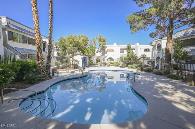 community pool featuring a patio area, a residential view, and fence