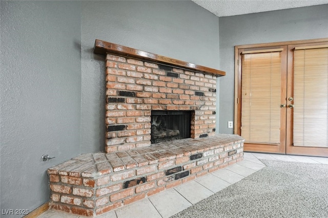 interior details with a fireplace, a textured wall, and a textured ceiling