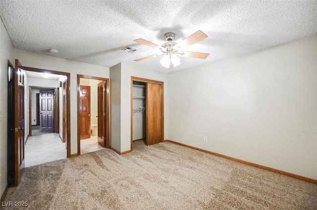 unfurnished bedroom featuring visible vents, a textured ceiling, a closet, carpet flooring, and baseboards