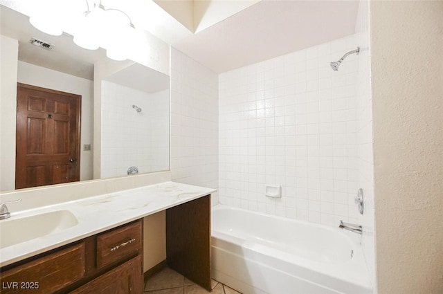 bathroom featuring tile patterned floors, visible vents, bathtub / shower combination, vanity, and a textured wall