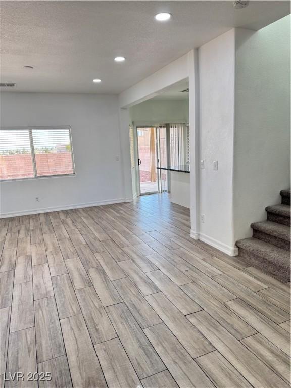 unfurnished room with a wealth of natural light, light wood-type flooring, and visible vents