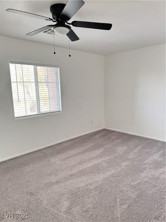 spare room with carpet flooring, baseboards, and a ceiling fan