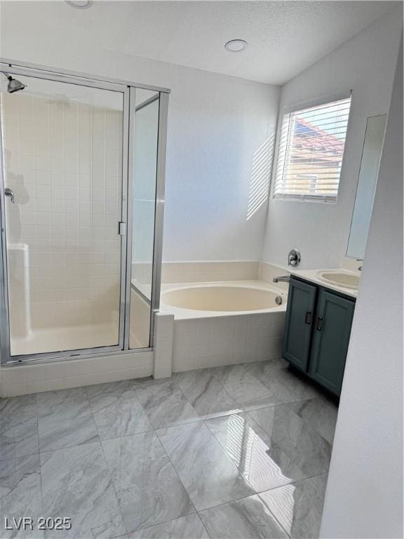 full bath featuring a garden tub, marble finish floor, a textured ceiling, a shower stall, and vanity