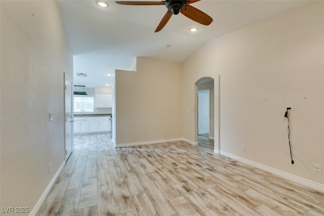 unfurnished room featuring recessed lighting, arched walkways, light wood-style flooring, and a ceiling fan