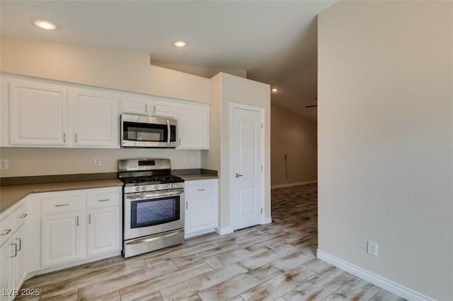 kitchen with recessed lighting, appliances with stainless steel finishes, white cabinets, and light wood finished floors