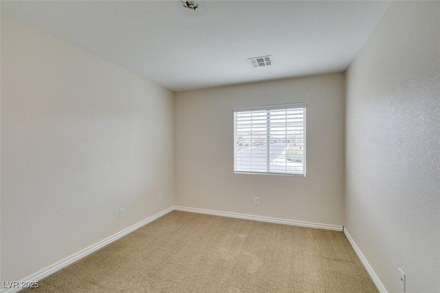 spare room featuring visible vents, baseboards, and light colored carpet