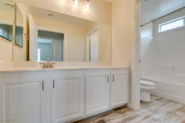 bathroom with vanity, shower / tub combination, toilet, and visible vents