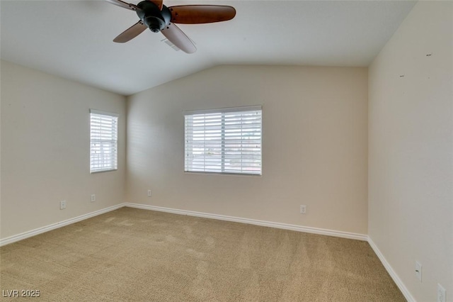 carpeted spare room featuring vaulted ceiling, baseboards, and ceiling fan