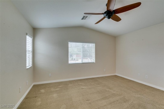 spare room with visible vents, baseboards, carpet, lofted ceiling, and a ceiling fan