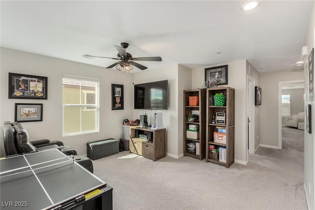 office area featuring light carpet, baseboards, and a ceiling fan