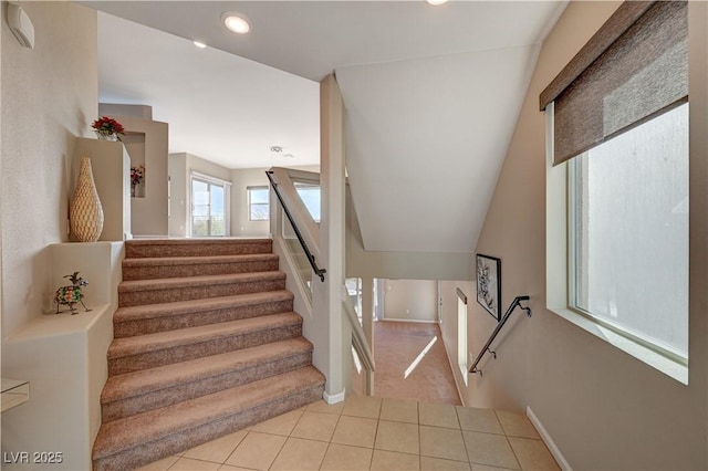 staircase featuring tile patterned floors, lofted ceiling, and recessed lighting