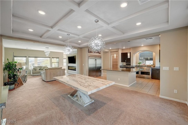 kitchen with open floor plan, light colored carpet, built in fridge, and coffered ceiling