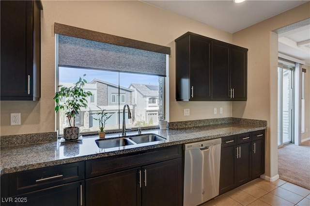 kitchen with a sink, stainless steel dishwasher, a wealth of natural light, and light tile patterned floors