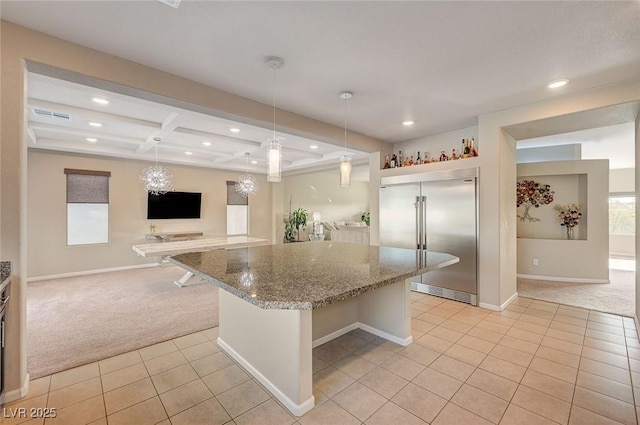 kitchen featuring light carpet, light tile patterned floors, a kitchen island, and stainless steel built in fridge