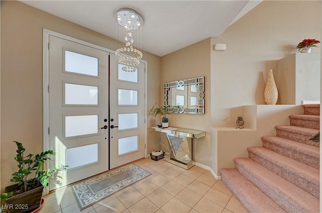 entryway featuring baseboards, stairs, light tile patterned floors, french doors, and an inviting chandelier