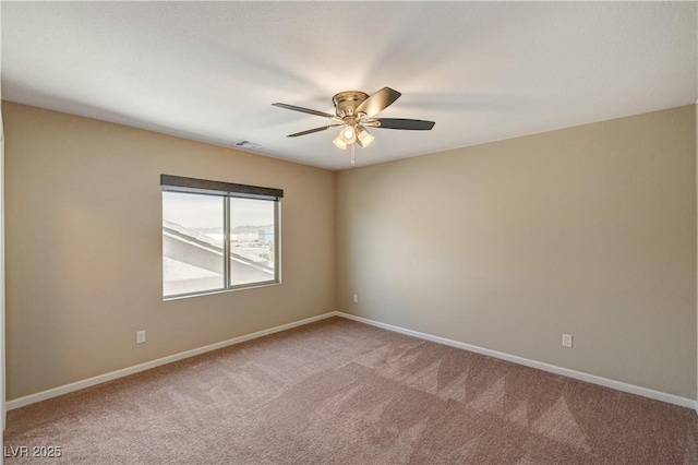 carpeted spare room featuring visible vents, baseboards, and ceiling fan