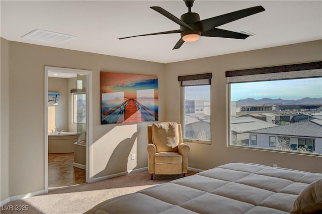 carpeted bedroom with visible vents, ceiling fan, ensuite bath, and baseboards