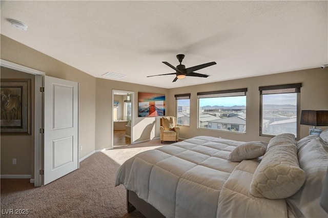 carpeted bedroom featuring visible vents, baseboards, ceiling fan, and ensuite bathroom