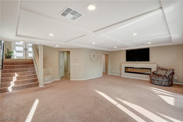 unfurnished living room with carpet, stairway, baseboards, and visible vents