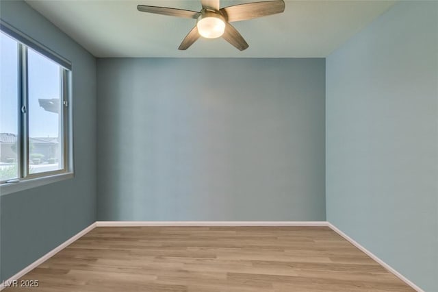 empty room featuring baseboards, light wood finished floors, and ceiling fan