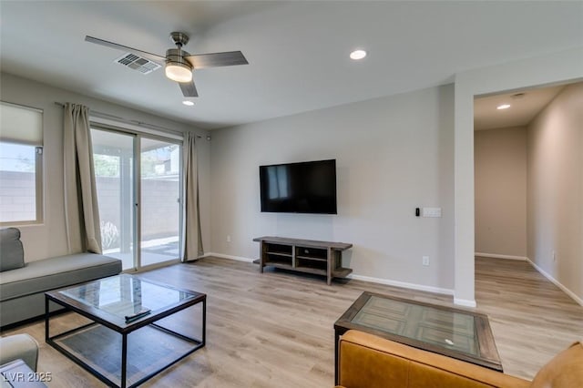 living area with light wood finished floors, baseboards, and a ceiling fan