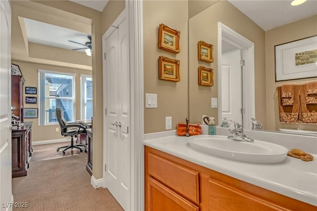 bathroom with baseboards, vanity, and a ceiling fan