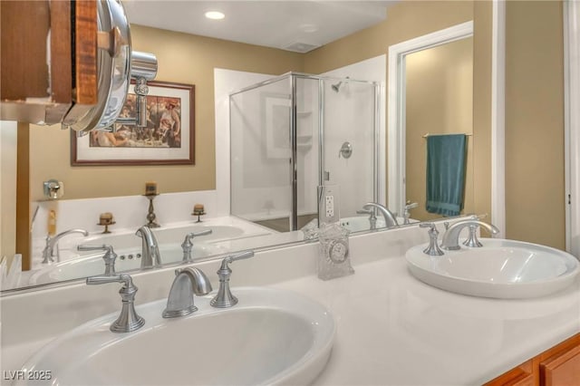 bathroom with double vanity, a shower stall, and a sink