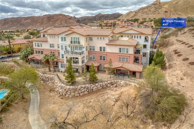 exterior space featuring a tiled roof, a mountain view, a residential view, and stucco siding