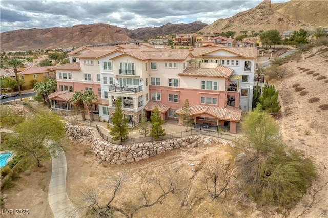 rear view of house with a residential view, stucco siding, a mountain view, and a tile roof