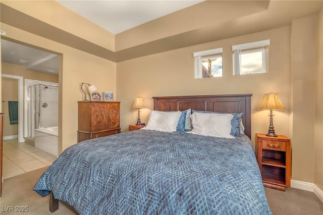 bedroom with light tile patterned flooring, connected bathroom, light colored carpet, and baseboards