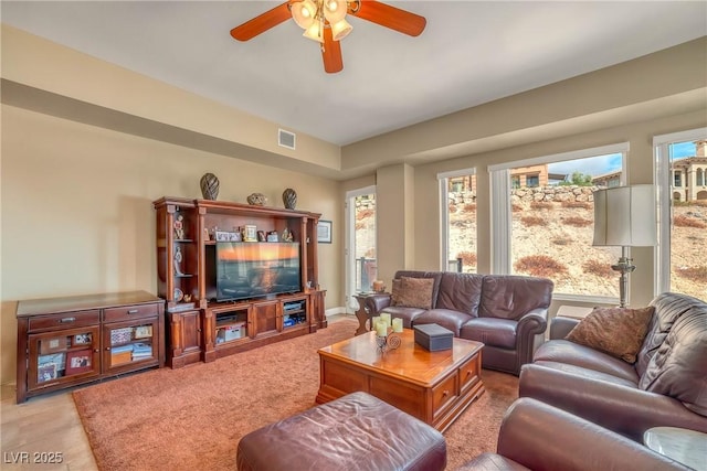 living area with visible vents and ceiling fan