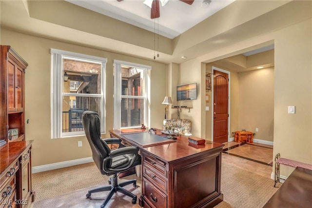 office with a raised ceiling, a ceiling fan, and baseboards