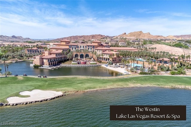 aerial view with a water and mountain view and view of golf course