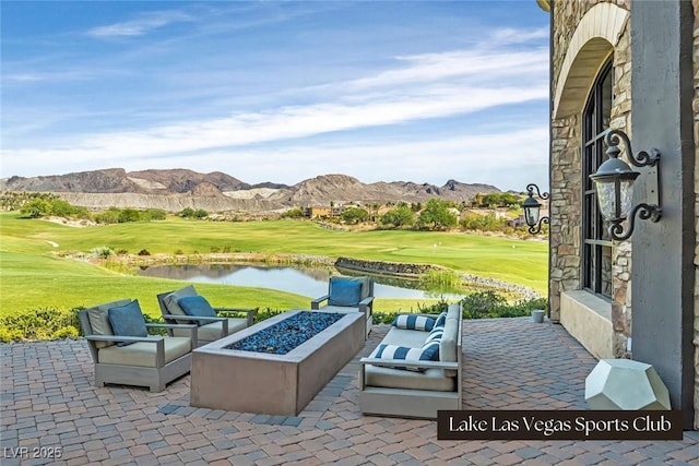 view of patio / terrace featuring golf course view, a water and mountain view, and an outdoor fire pit