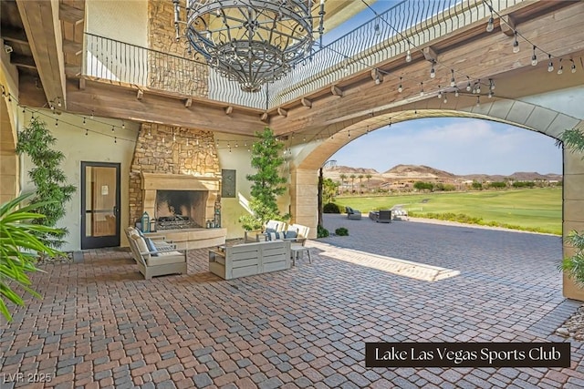 view of patio / terrace with a mountain view and an outdoor living space with a fireplace